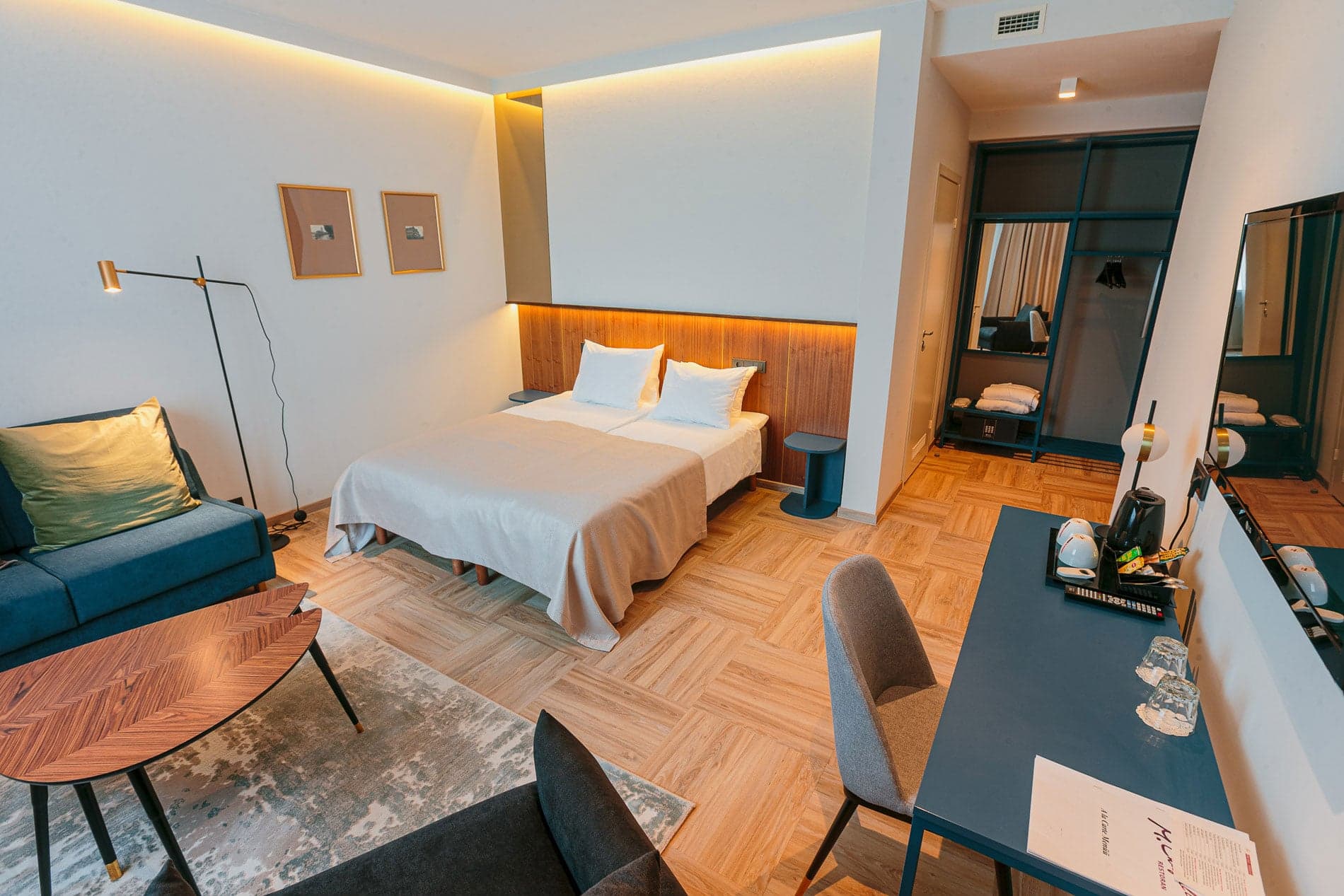Kaasaegne hotellituba voodi, diivani ja kirjutuslauaga